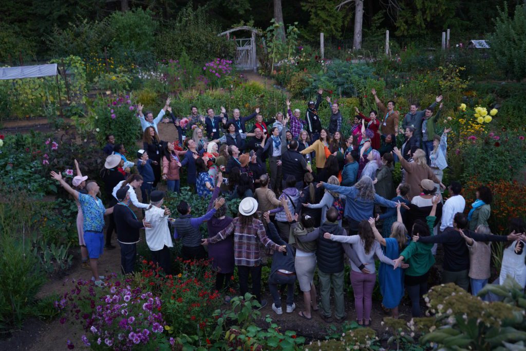Hollyhock´s staff and students together in the garden celebrating and raising hands.