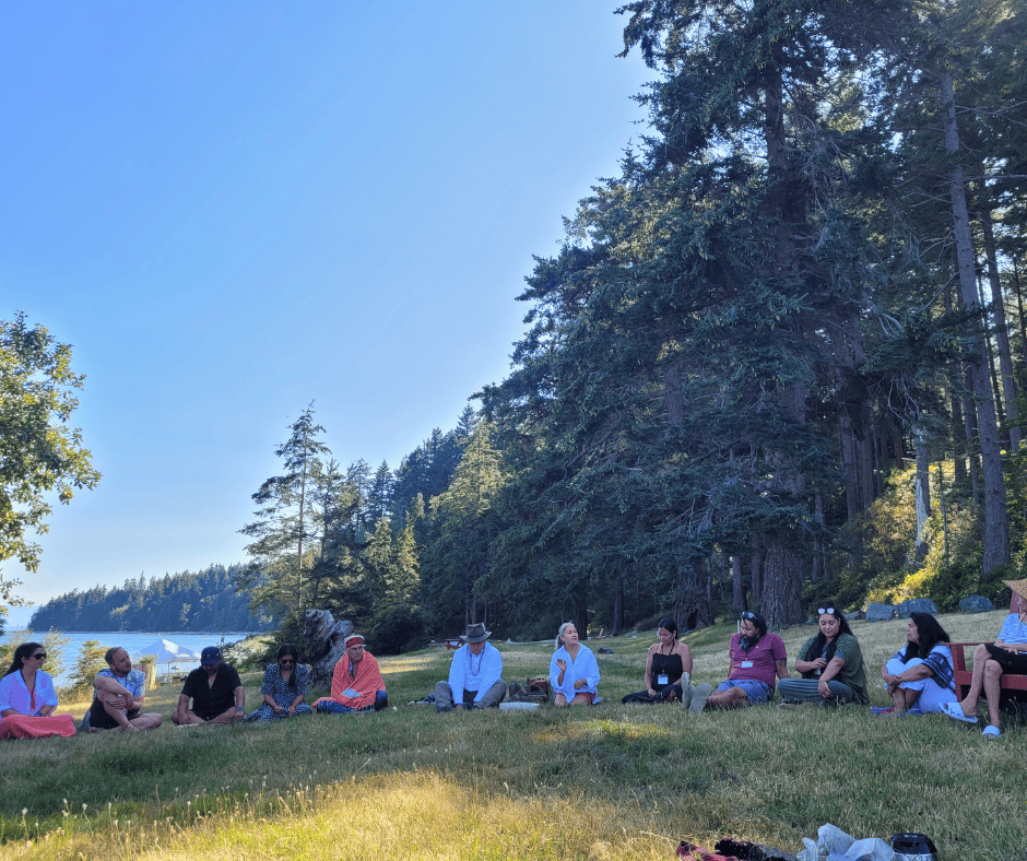 A group of people sitting in a circle outside